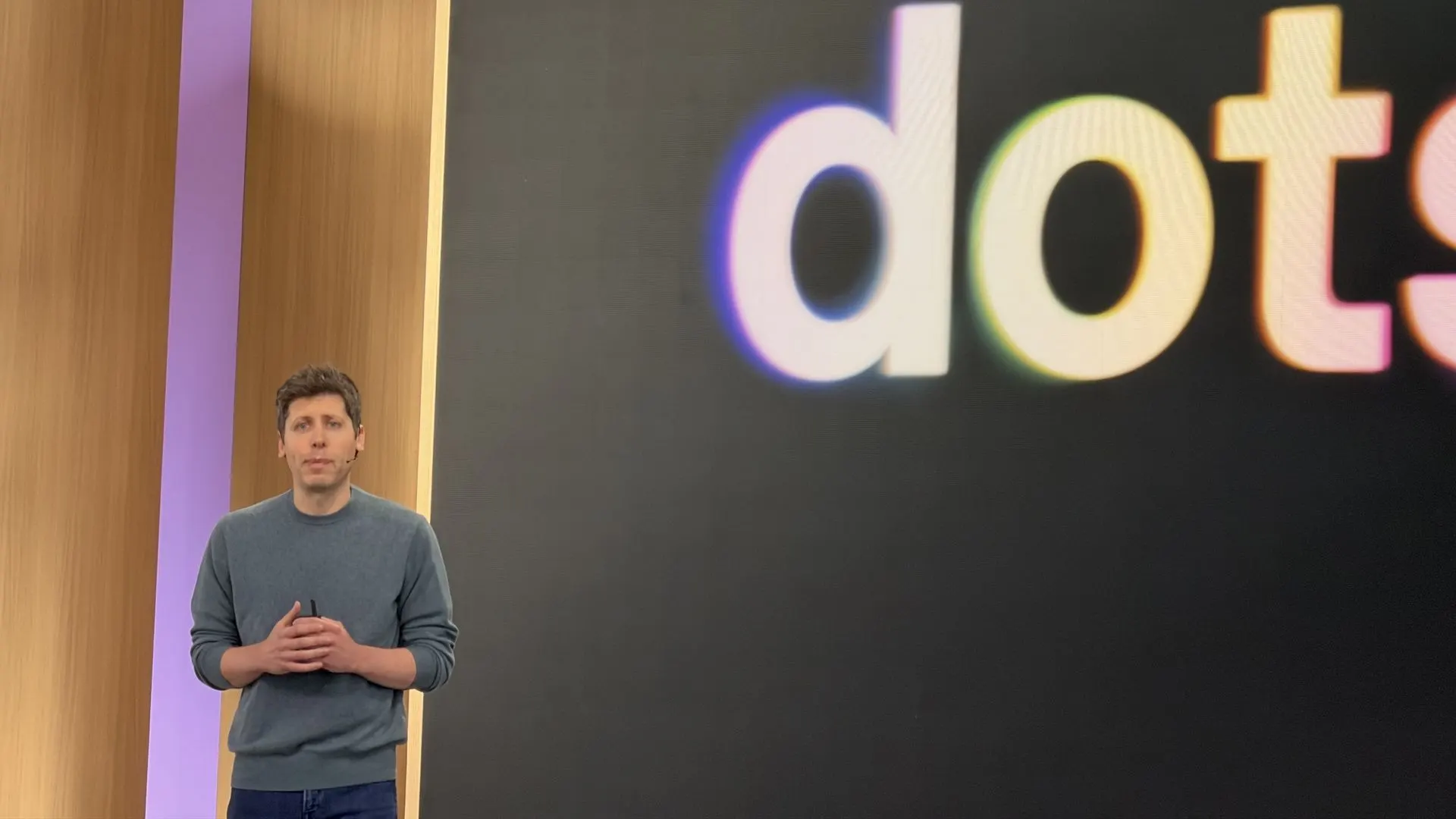 Sam Altman speaking at the OpenAI DevDay 2026 dots launch, with the colorful dots wordmark behind him